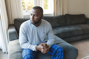 Person sitting indoors while thinking about benzo addiction treatment