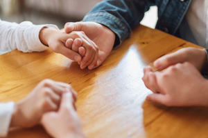 People holding hands at a family therapy program