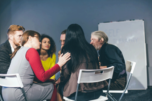 People sitting in a circle at a group therapy program